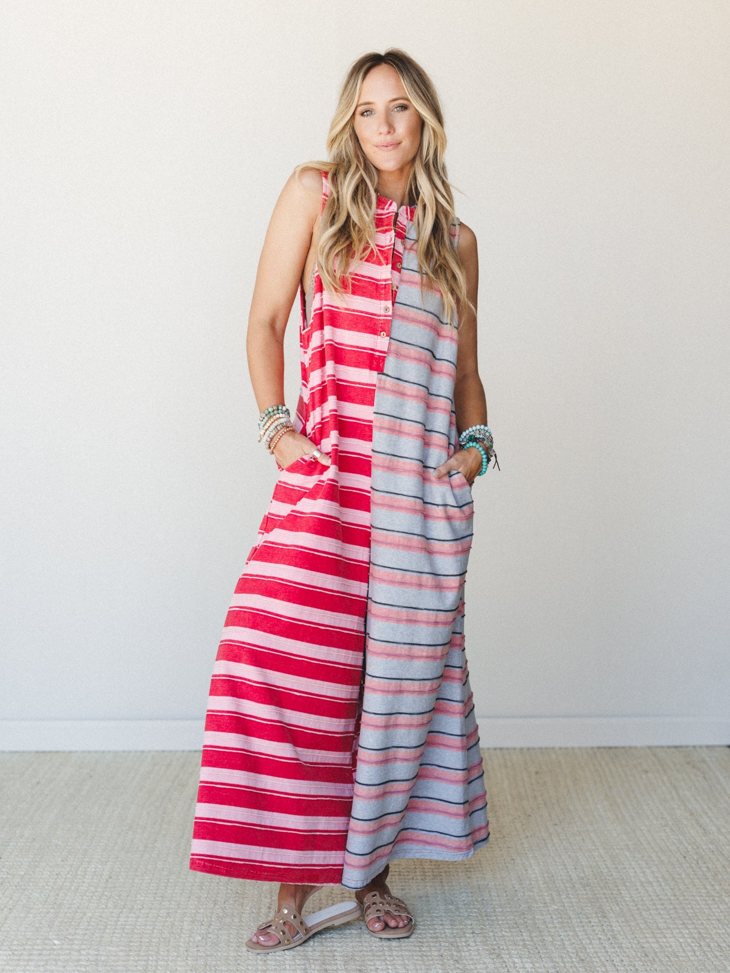 A breezy color-blocked maxi jumpsuit in bold red and soft grey stripes worn with flat sandals and stacked turquoise bracelets — effortless and a little unexpected, like your most fun summer outfit that also has pockets.