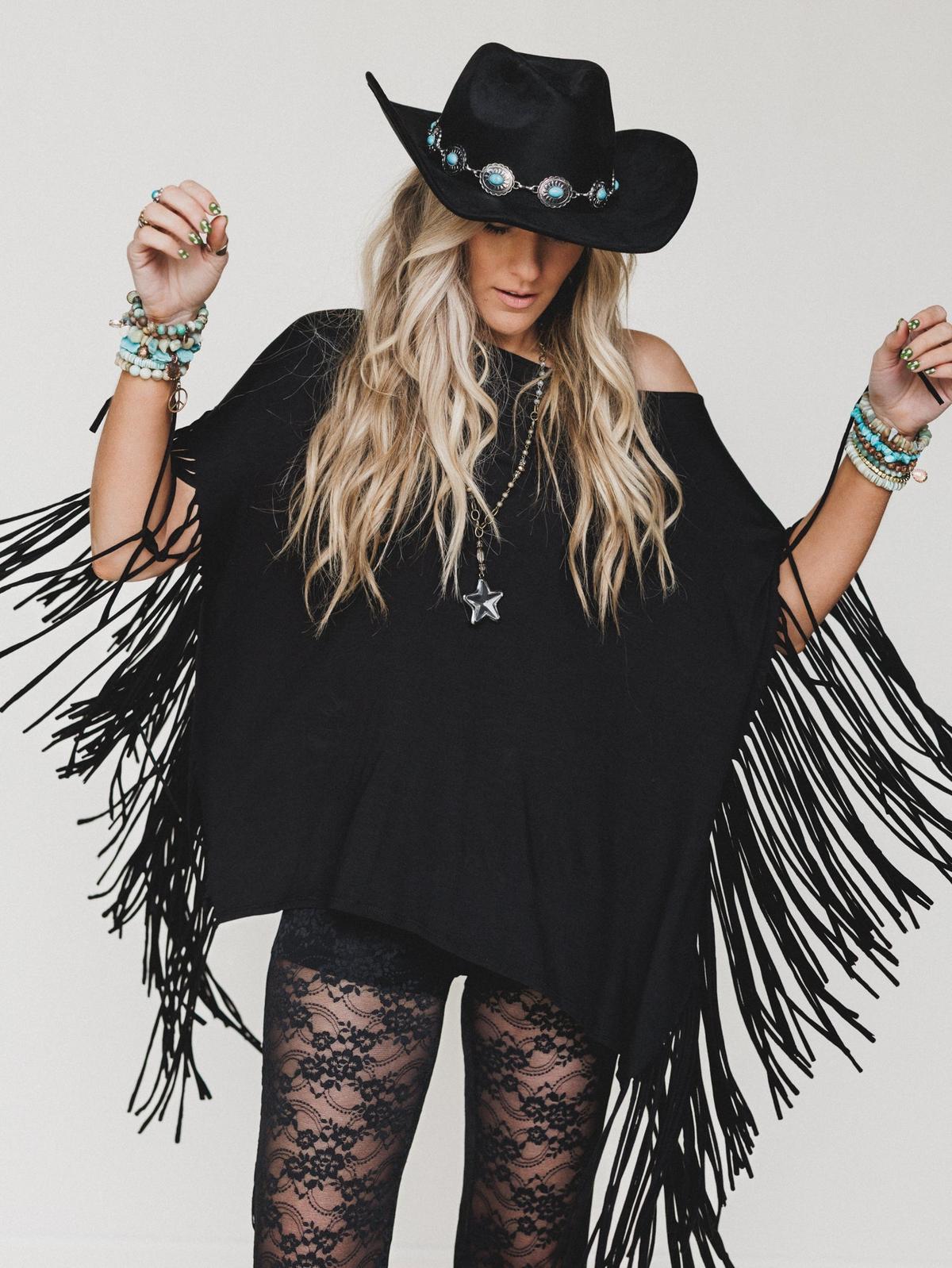 Model wearing a fringe top styled for a boho-western fall outfit