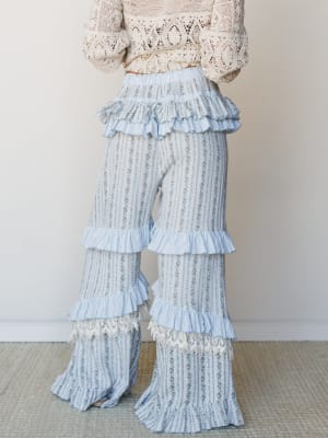 A dreamy pair of wide-leg floral stripe pants with layered ruffle tiers and lace hem trim, styled with a cream crochet top — soft, romantic, and a little bit fairy-tale.