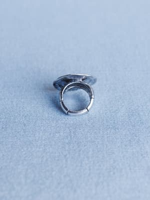 Silver ring on a light blue textured surface