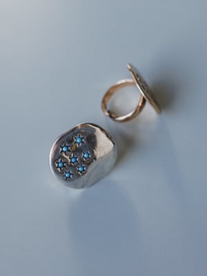 Silver rings with blue gemstones on a light gray background