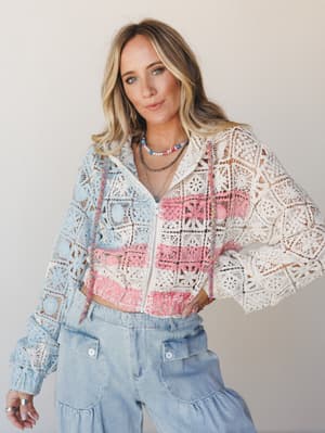 A color-blocked crochet zip-up jacket in cream, baby blue, and pink worn over wide-leg light wash denim pants, styled with layered beaded and chain necklaces — the kind of outfit that feels like it was pulled together effortlessly but definitely wasn