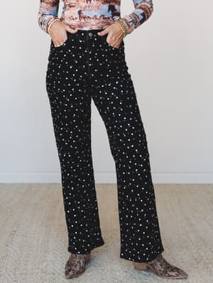 Black wide-leg jeans covered in all-over silver sequins are styled with a horse-print long-sleeve top and leopard western ankle boots — the kind of outfit that makes a Tuesday feel like an occasion.