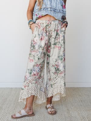 Wide-leg floral pants with a crochet lace hem take center stage here — the kind of easy, expressive bottom that makes a Saturday feel intentional without trying too hard.