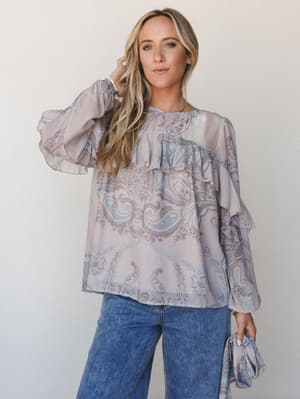 A flowy paisley-print blouse in muted mauve and periwinkle blue styled with wide-leg denim — the kind of top that looks effortless but clearly wasn't an accident.
