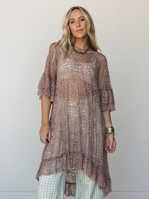 A flowy taupe lace tunic layered over sage gingham wide-leg pants, styled with turquoise and gold jewelry — the kind of effortlessly romantic outfit that looks like it came together without trying.