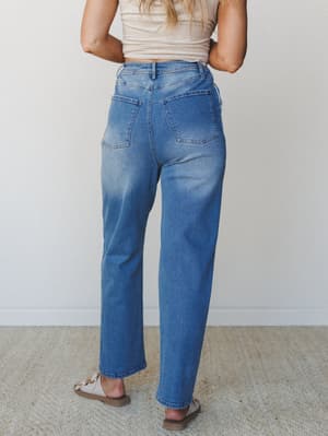 Back view of medium wash wide-leg jeans styled with a cropped sand tee and tan sandals — the kind of effortless everyday denim that looks like it's been yours for years.