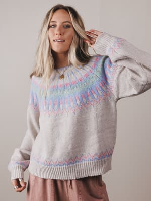 Woman wearing a patterned sweater with a neutral background