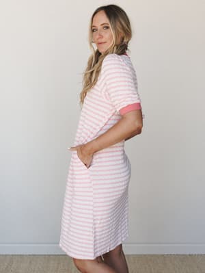 A striped pink and white knit dress with ribbed contrast cuffs and side pockets — the kind of thing you'd happily wear all day and never want to take off.