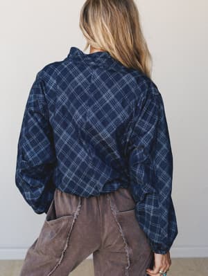 Shot from behind, this navy plaid jacket has a lived-in, effortless quality — voluminous sleeves and a relaxed silhouette styled with dusty mauve wide-leg pants for that perfectly undone fall look.