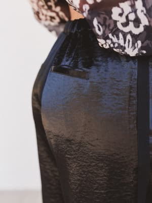 Black textured skirt with a patterned top on a white background