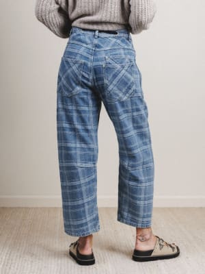 Person wearing blue plaid pants with a neutral background