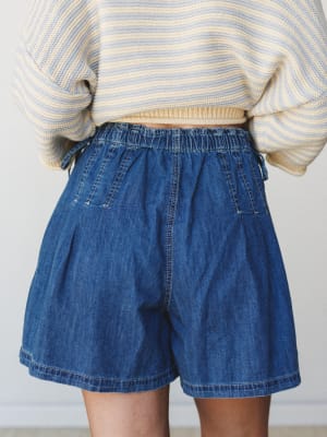 A relaxed mid-shot of wide-leg denim shorts with an elastic waistband, paired with a cropped stripe knit sweater — the kind of effortless summer combo that lives permanently in your weekend rotation.