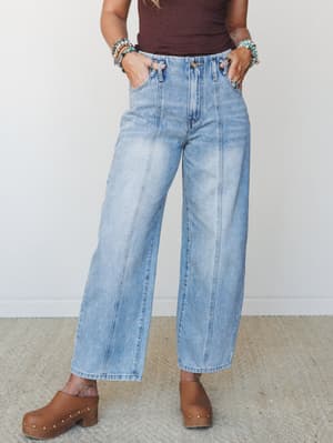 Light wash wide-leg jeans with a relaxed, barrel-fit silhouette styled with a burgundy tank and wood-studded clogs — the kind of outfit that looks effortless but clearly had a thought behind it.
