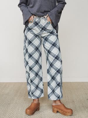 Wide-leg plaid pants in a cream and navy bias-cut plaid styled with an oversized charcoal sweatshirt and tan studded clogs — the kind of outfit that looks effortless but very much on purpose.