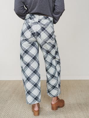 Shot from behind, these wide-leg plaid pants in cream and navy are styled with a charcoal long-sleeve and wood-heeled clogs — the kind of effortless combo that makes a statement without trying.