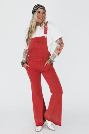 Person wearing red overalls and a white shirt with a patterned headband on a white background