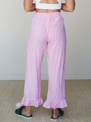 Back view of pink gingham wide-leg pants with ruffle hems, styled with a white textured crop top and green fuzzy slippers — playful and a little dreamy, like your most cheerful morning-after outfit.