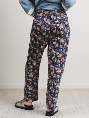 Person wearing navy floral pants with a light background