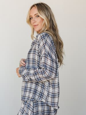 A relaxed plaid set in navy and cream photographed from a three-quarter angle — the kind of outfit that makes staying in feel like a deliberate choice.