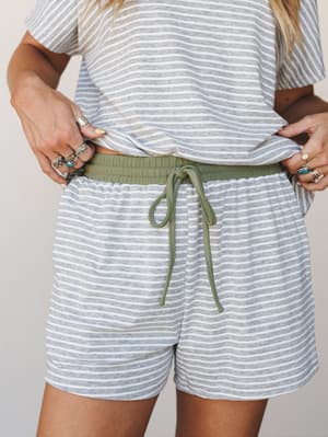 A close-up of a striped knit shorts and matching top set styled with stacked silver rings — effortlessly relaxed with that soft, lived-in feel that makes you want to wear it all day.