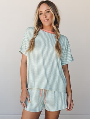 A matching striped two-piece set in soft pistachio and cream, styled with a relaxed oversized tee and drawstring shorts — the kind of set that blurs the line between a cozy morning at home and a casual coffee run.
