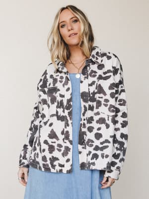 A relaxed cow-print shacket layered over a soft blue midi dress — the kind of effortless, personality-forward outfit that makes a statement without trying too hard.