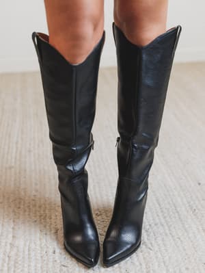 Black knee-high boots on a textured surface