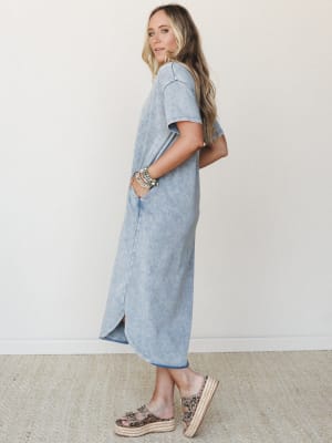 A relaxed maxi tee dress in a washed cloud denim finish, styled with stacked beaded bracelets and leopard print platform sandals — the kind of effortless outfit that looks like you tried just enough.