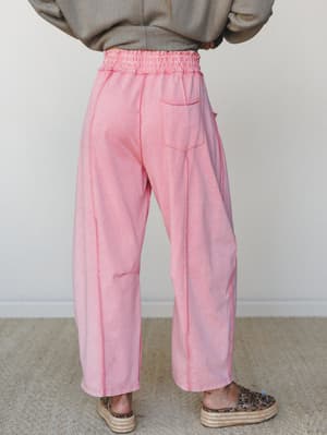 A back-view shot of relaxed wide-leg pants in a washed dusty rose, styled with a herringbone oversized top and espadrille platform sneakers — the kind of outfit that looks effortless but definitely took a second thought.