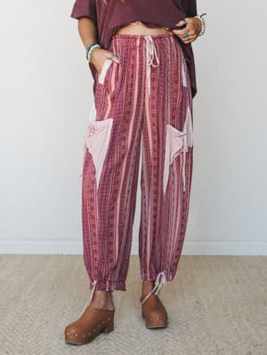 Relaxed harem-style pants in a warm mauve mixed print, styled with a cropped burgundy tee and wood-studded clogs — the kind of outfit that looks like it was effortless but absolutely wasn't.