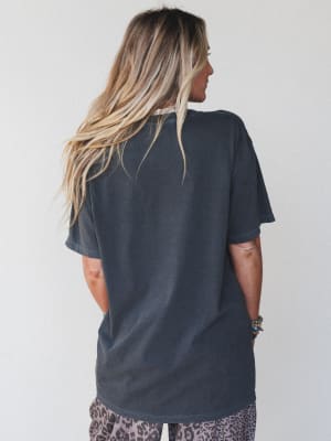 Person wearing a dark gray t-shirt with a plain background