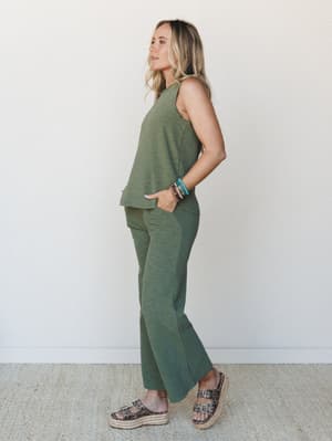 A matching olive two-piece set — sleeveless tank and wide-leg pants in a heathered knit — styled with stacked beaded bracelets and leopard platform sandals for an effortlessly pulled-together everyday look.