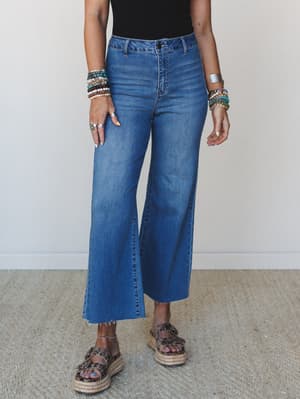 High-waist wide-leg cropped jeans in a medium wash denim, styled with espadrille platform sandals and stacked beaded bracelets — the kind of effortless, put-together look that works from a coffee run to a weekend lunch.