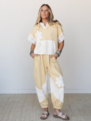 A butter yellow matching set with white crochet lace paneling and floral appliqué details — the kind of outfit that makes a Saturday morning feel intentional.