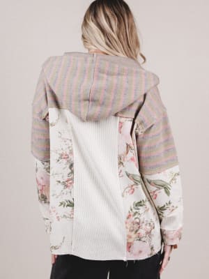 Person wearing a jacket with floral patterns on a plain background