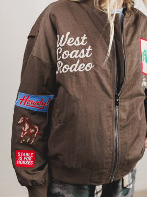 Brown jacket with 'West Coast Rodeo' text and patches on a plain background