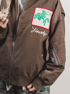 Brown jacket with a patch featuring a horse and 'Howdy' text on a plain background