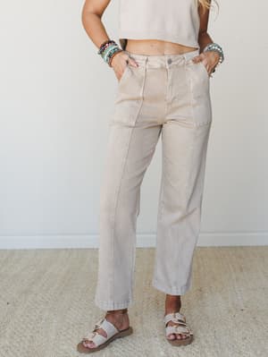 Wide-leg utility pants in a washed sand tone styled with a cropped knit top, buckle sandals, and a stack of colorful beaded bracelets — effortless and easy, like a Saturday that actually came together.