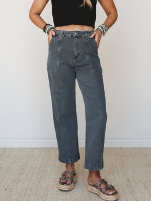 Faded charcoal wide-leg pants styled with a black crop top, stacked beaded bracelets, and platform espadrille sandals — effortless and a little utilitarian, in the best way.