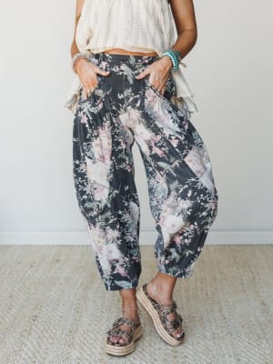 Flowy floral barrel-leg pants in a washed charcoal denim paired with a cream knit top and platform espadrille sandals — the kind of outfit that looks effortless but was absolutely thought about.
