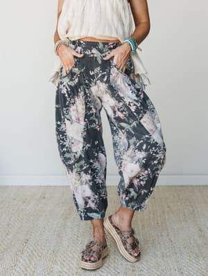 Flowy floral barrel-leg pants in a washed charcoal denim paired with a cream knit top and platform espadrille sandals — the kind of outfit that looks effortless but was absolutely thought about.