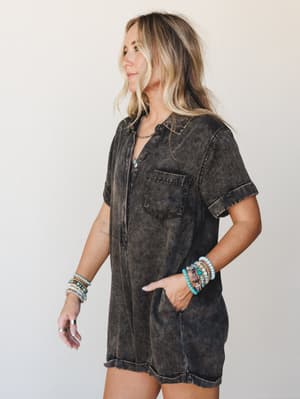 A mineral-washed short romper in ash black styled with stacked turquoise and beaded bracelets — the kind of effortless one-and-done outfit that looks like you tried just enough.