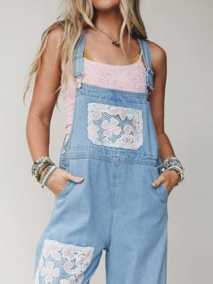 Light wash denim overalls with crochet lace patch pockets steal the show here — layered over a pink lace tank, stacked with beaded bracelets, it's the kind of outfit that feels like it was assembled with intention and a really good eye.