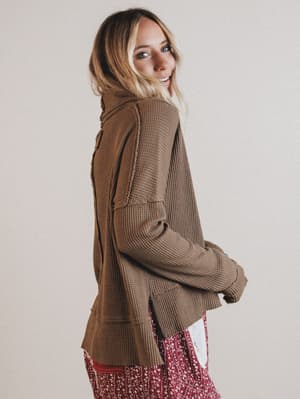 Woman wearing a brown textured thermal against a plain background