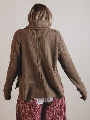 Person wearing a brown thermal with a plain background