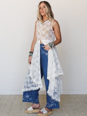 A sheer cream lace maxi duster layered over embroidered wide-leg denim — the kind of outfit that looks effortless but took exactly the right amount of thought.
