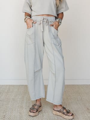 Wide-leg drawstring pants in a washed dove grey paired with a matching cropped sweatshirt top, styled with platform espadrille sandals and stacked boho bracelets — relaxed and put-together at the same time.