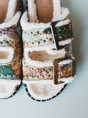 Decorative sandals with multicolored beading and fur on a light background