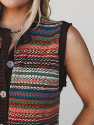 Multicolored striped sleeveless top worn by a person against a neutral background